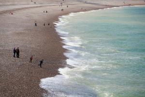 a group of people walking on the beach at Hotel Aguado in Dieppe