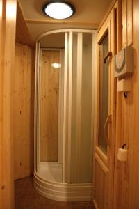 a walk in shower in a room with wooden walls at Chata Krajinka in Ždiar
