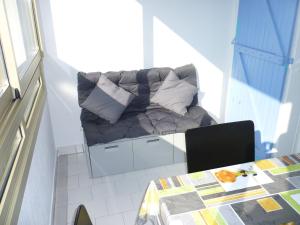 a couch sitting in the corner of a room with a table at Les Jardins Du Golf – Mandelieu in Mandelieu-la-Napoule