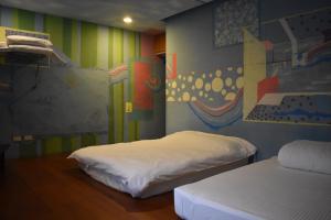a room with two beds and a painting on the wall at Being Outdoor in Gongliao