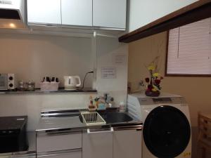 kuchnia z kuchenką i zmywarką do naczyń w obiekcie Keys House w Tokio