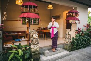 a woman standing on a statue in a room at The Runik Ubud in Ubud
