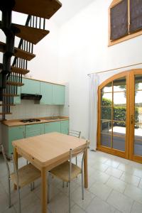a kitchen with a wooden table and some chairs at Villaggio Teodorico in Punta Marina