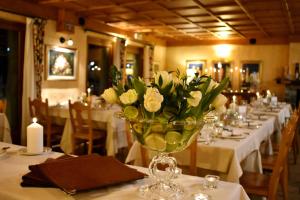 un jarrón de flores sobre una mesa en un restaurante en Le Rocher Hotel en Champoluc