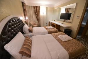 A bed or beds in a room at Golden Deluxe Hotel