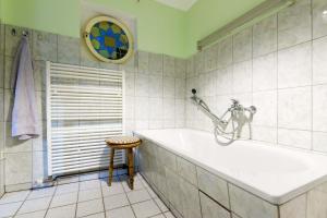 a bathroom with a tub and a stool and a window at Cottage near centrum, paradise in Berlin +22 photos