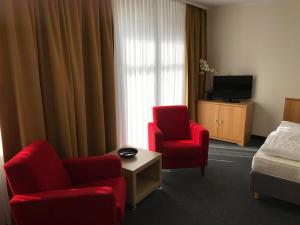 a hotel room with two chairs and a bed and a television at Ferienwohnung Nummer 8 Sellin in Ostseebad Sellin
