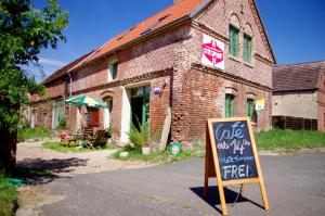 a brick building with a sign in front of it at Stützpunkt Trebitz - Gästezimmer am Europaradweg R1 in Brück