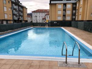 een groot zwembad in het midden van sommige gebouwen bij Apartamento Unquera - Cantabria in Unquera