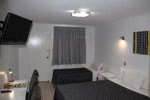 a small room with a bed and a television at Park View Motel in Gladstone