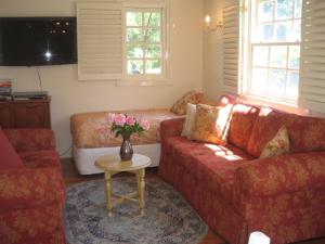 a living room with a couch and a table with flowers at Annie's cottage in Kurrajong