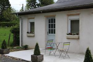a table and chairs in front of a white house at Ferme de la Cacheterie, in Fleury-la-Forêt
