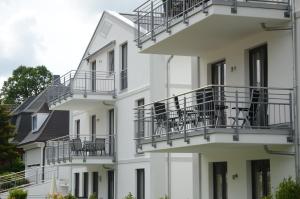 a white building with balconies and tables on it at Residenz Margarete - Apt. 2.5 in Binz