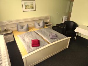 a bedroom with a bed with a red pillow on it at Pension Haus Rodenstein in Altenbrak