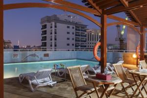 a patio with a table and chairs and a pool at La Villa Najd Hotel Apartments in Dubai