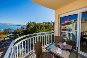 d'un balcon avec une table et des chaises et une vue sur l'océan. dans l'établissement Apartments Nada, à Trogir