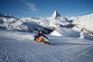 a person is skiing down a snow covered mountain at Chalet Arnold in Zermatt