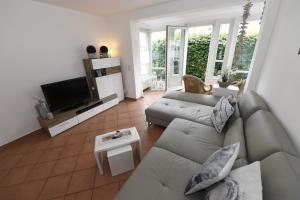 ein Wohnzimmer mit Couch und Fernseher in der Unterkunft Haus "Concordia" in Binz - WG 02 "Seedorf" mit Terrasse, strandnah in Binz