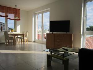 a living room with a tv and a table with chairs at Ferienwohnung de Jong in Sendenhorst