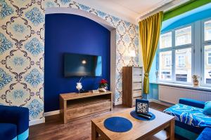 a living room with blue walls and a blue couch at Apartament Kowary - Na Kowarskiej Starówce II in Kowary