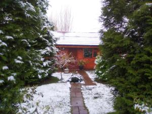 a house with snow on the ground in front of it at Manor Garden Lodge in Wirral