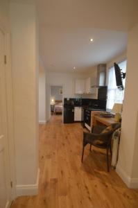 een keuken en een woonkamer met een houten vloer bij Little Weech in Dawlish