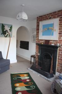 a living room with a fireplace and a brick wall at Whitstable Tree House Retreat in Whitstable