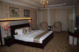 Habitación de hotel con 1 cama y 2 sillas en Al Mokhmalia Residential Units, en Medina