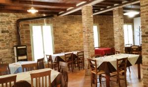 a dining room with tables and chairs and brick walls at Agriturismo di Sordiglio in Casina