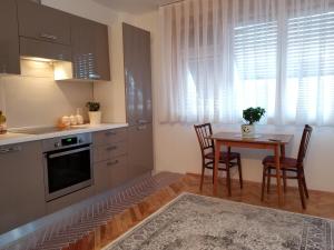 a kitchen with a table and chairs and a table and a window at Super Central & Panoramic - Leo's Apartment in Pristina