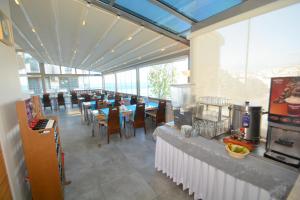 a dining room with tables and chairs and windows at Istankoy Hotel in Kusadası