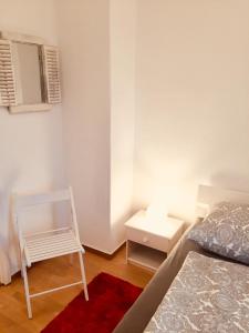 a small bedroom with a bed and a white chair at Ferienwohnung Tiffy in Chemnitz