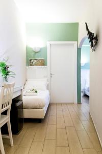 ローマにあるB&B カセッタ ローマのベッド、デスク、ドアが備わる客室です。