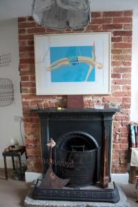 a brick fireplace with a picture of a woman on it at Whitstable Tree House Retreat in Whitstable