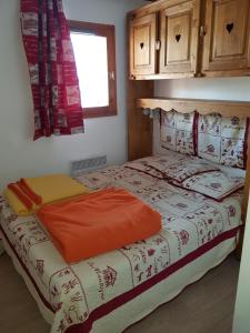ヴァルマニエにあるLes Lumières De Neige IIのオレンジの枕が付いたベッドが備わる客室です。