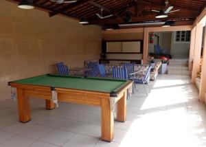 a pool table in the middle of a patio with chairs at Pousada Monjope in Igarassu