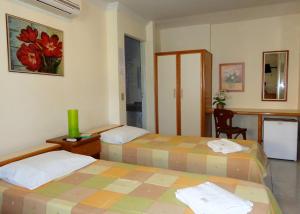 a hotel room with two beds and a desk at Pousada Monjope in Igarassu +32 photos