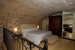 a bedroom with a bed and a brick wall at Appartamento San Martino in Spoleto
