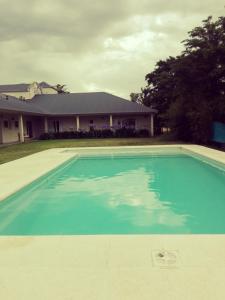 una grande piscina blu di fronte a una casa di Hosteria Ruphay a Tandil
