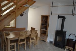 a dining room with a table and a wood stove at ALPIN apartma in Bovec