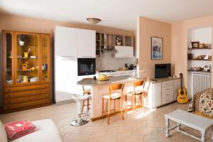 アローナにあるLa Casa di Cristinaの白いキャビネットとキッチンアイランド付きのキッチン