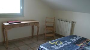 1 dormitorio con escritorio y silla junto a la cama en l'Oulibo, en Villeneuve-les-Corbières