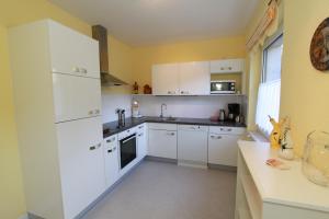 a kitchen with white cabinets and a white refrigerator at Haus Burgman Bad Gastein - appartement met 4 slaapkamers in Bad Gastein