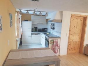 a kitchen with white cabinets and a table in it at Ferienhaus Schaffrath in Hohnstein