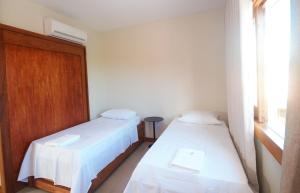 a room with two beds and a window at Casa Ohana in Barra Grande
