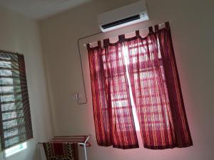 een raam met een rood gordijn in een kamer bij Lynn Homestay Alor Setar in Alor Setar