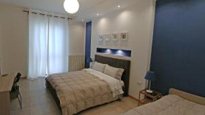 1 dormitorio con 2 camas y pared azul en B&B Villa Monterosa con Piscina, en Castronno