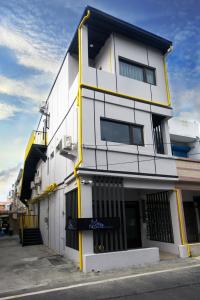 a white building with yellow accents on the side of it at Meet the Bay Homestay in Nanwan