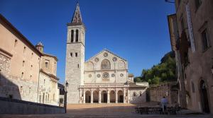 a church with a tall tower with a steeple at Appartamento San Martino in Spoleto