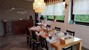 un comedor con mesa y sillas con comida. en B&B Villa Monterosa con Piscina, en Castronno
